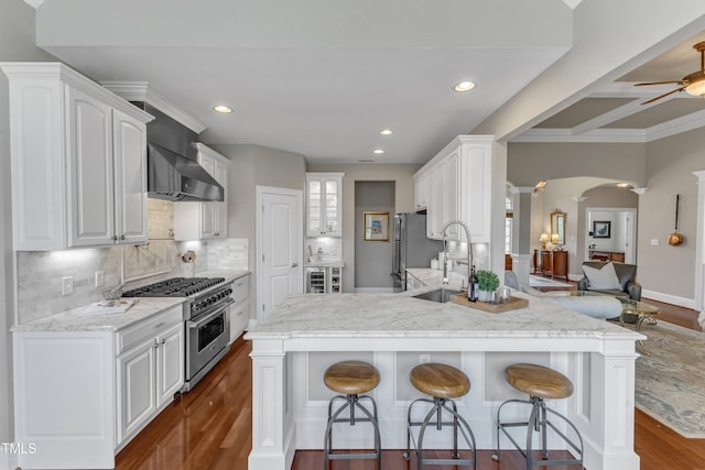 7800 Twin Pines Way, Fuquay Varina, NC 27526 - kitchen with stainless steel appliances, a sink, decorative columns, a breakfast bar, and recessed lighting