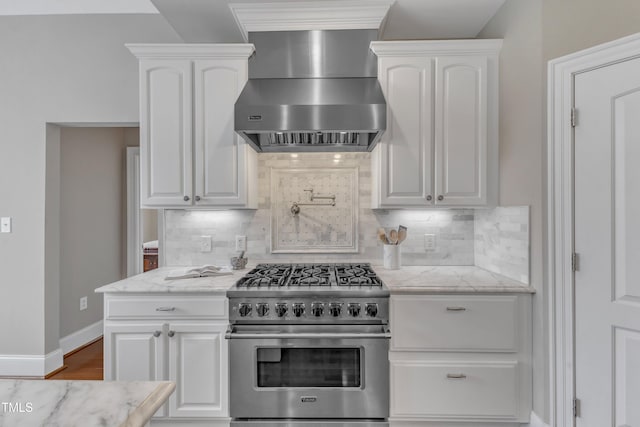7800 Twin Pines Way, Fuquay Varina, NC 27526 - kitchen featuring stainless steel stove, wall chimney range hood, white cabinetry, and tasteful backsplash