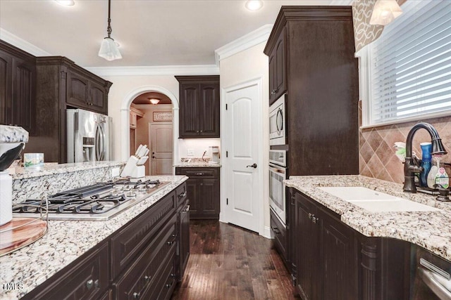 479 Perkins Rd, Goldsboro, NC 27530 - kitchen featuring appliances with stainless steel finishes, a sink, arched walkways, dark brown cabinetry, and dark wood finished floors