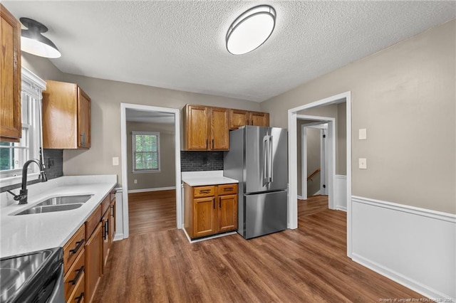 2308 Keith Dr, Raleigh, NC 27610 - kitchen with freestanding refrigerator, a sink, electric range, brown cabinets, and a textured ceiling