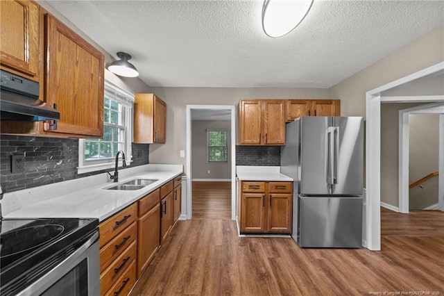 2308 Keith Dr, Raleigh, NC 27610 - kitchen with appliances with stainless steel finishes, a sink, under cabinet range hood, dark wood-style flooring, and a textured ceiling