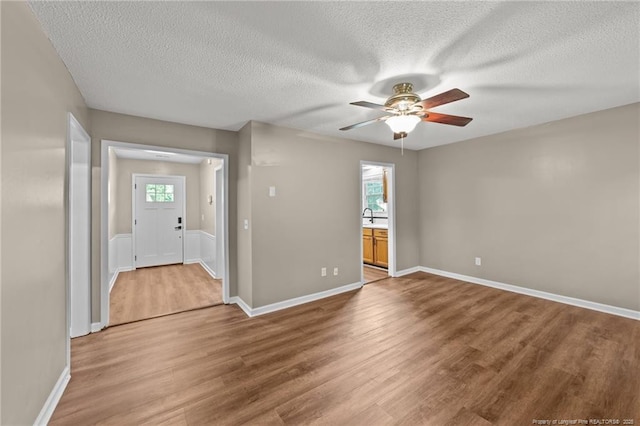 2308 Keith Dr, Raleigh, NC 27610 - spare room featuring a ceiling fan, a textured ceiling, light wood-type flooring, and baseboards