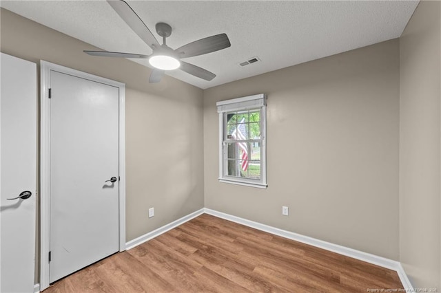 2308 Keith Dr, Raleigh, NC 27610 - unfurnished bedroom with baseboards, light wood-type flooring, ceiling fan, and a textured ceiling