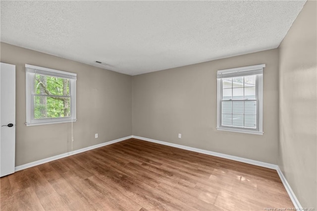 2308 Keith Dr, Raleigh, NC 27610 - empty room with wood finished floors, a textured ceiling, and baseboards