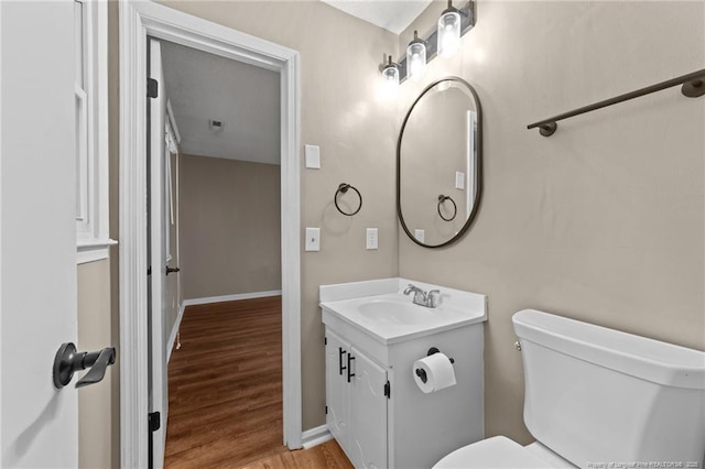 2308 Keith Dr, Raleigh, NC 27610 - bathroom featuring vanity, toilet, wood finished floors, and baseboards