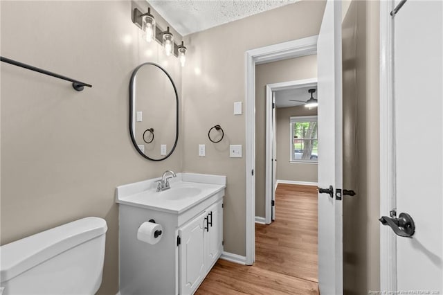 2308 Keith Dr, Raleigh, NC 27610 - bathroom featuring toilet, vanity, baseboards, wood finished floors, and ceiling fan