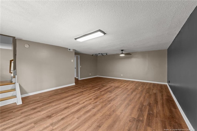 2308 Keith Dr, Raleigh, NC 27610 - below grade area featuring a textured ceiling, ceiling fan, wood finished floors, baseboards, and stairs