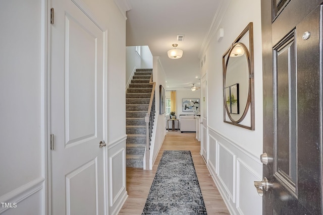 128 Bruce Dr, Dunn, NC 28334 - foyer featuring stairs, light wood-type flooring, a decorative wall, ceiling fan, and a wainscoted wall
