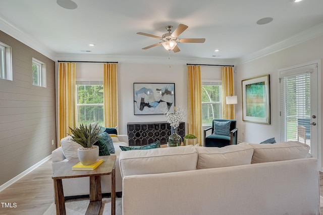 128 Bruce Dr, Dunn, NC 28334 - living area featuring light wood-style floors, ornamental molding, baseboards, ceiling fan, and wood walls