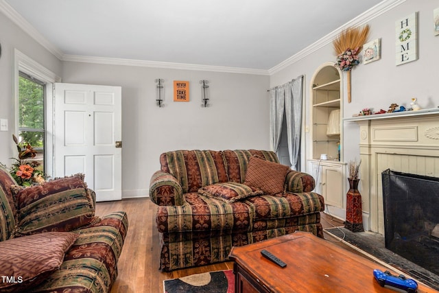 940 Hill St, Rocky Mount, NC 27801 - living room featuring wood finished floors, crown molding, a brick fireplace, built in shelves, and baseboards