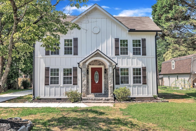 305 W Canary St, Dunn, NC 28334 - tudor-style house featuring board and batten siding, a front yard, stone siding, and roof with shingles