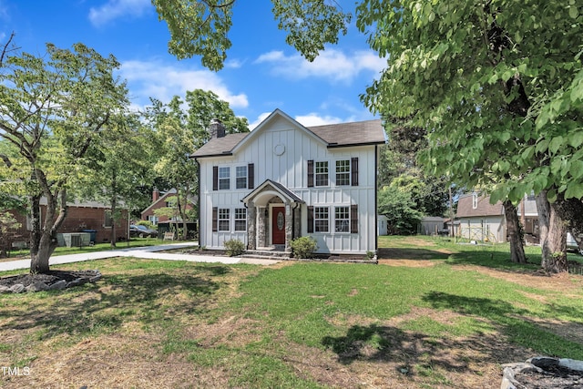 305 W Canary St, Dunn, NC 28334 - view of front of home featuring board and batten siding, a front lawn, a chimney, and a shingled roof