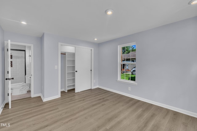 305 W Canary St, Dunn, NC 28334 - unfurnished bedroom featuring light wood finished floors, baseboards, a closet, recessed lighting, and ensuite bath