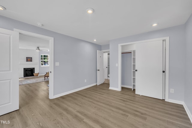 305 W Canary St, Dunn, NC 28334 - unfurnished bedroom with light wood-style flooring, baseboards, a fireplace, recessed lighting, and a closet