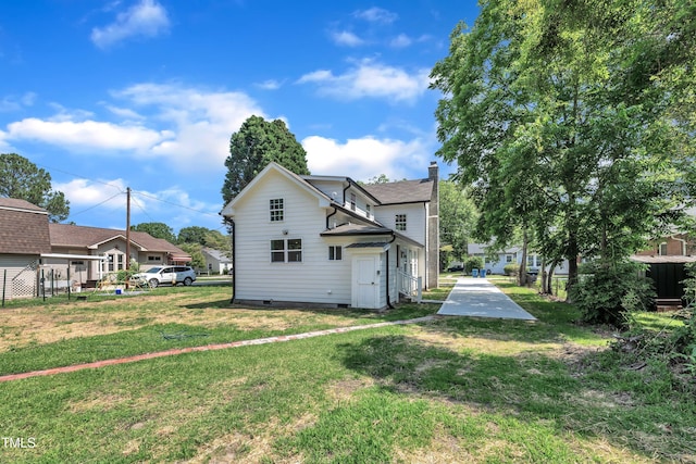 305 W Canary St, Dunn, NC 28334 - rear view of house with crawl space, a yard, a residential view, and a chimney