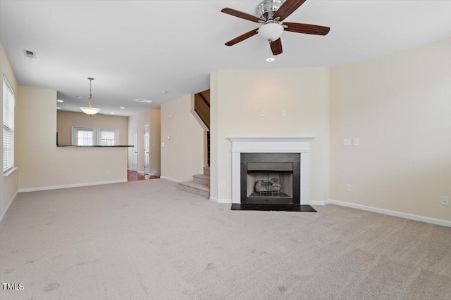 229 Michigan Ave, Cary, NC 27519 - unfurnished living room with a fireplace with flush hearth, carpet flooring, ceiling fan, baseboards, and stairway