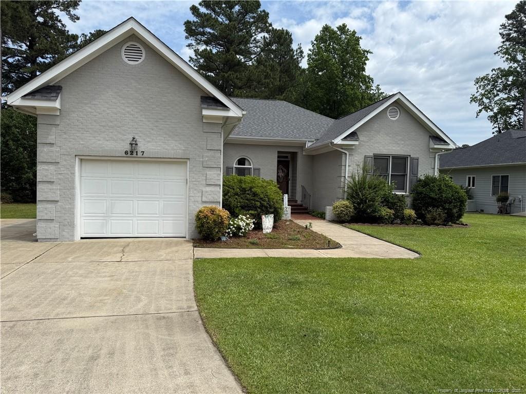 6217 Falkland Ct, Fayetteville, NC 28311 - view of front of house featuring concrete driveway, a front lawn, brick siding, and a garage