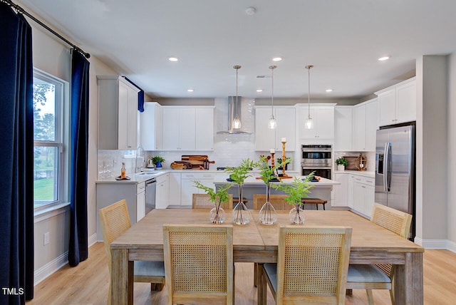 2512 Stonington Dr, Cary, NC 27523 - kitchen with wall chimney exhaust hood, stainless steel appliances, decorative backsplash, light wood-type flooring, and recessed lighting