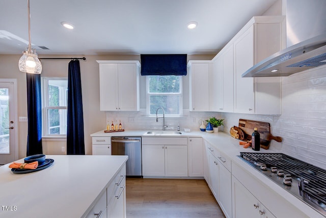 2512 Stonington Dr, Cary, NC 27523 - kitchen featuring stainless steel appliances, wall chimney exhaust hood, a sink, light countertops, and tasteful backsplash