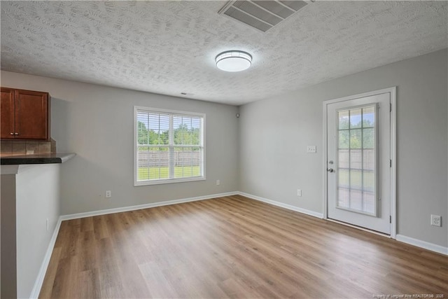 153 Abbey Ln, Raeford, NC 28376 - unfurnished living room featuring light wood-style floors, baseboards, and a textured ceiling
