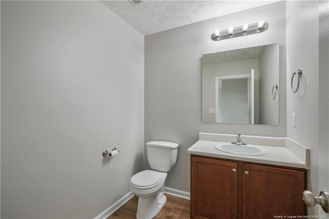 153 Abbey Ln, Raeford, NC 28376 - bathroom with toilet, wood finished floors, vanity, baseboards, and a textured ceiling