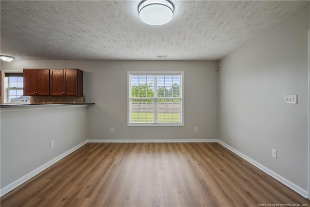 153 Abbey Ln, Raeford, NC 28376 - unfurnished dining area featuring a textured ceiling, wood finished floors, healthy amount of natural light, and baseboards