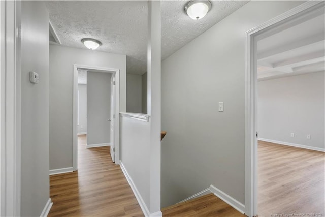153 Abbey Ln, Raeford, NC 28376 - hallway featuring an upstairs landing, wood finished floors, baseboards, and a textured ceiling