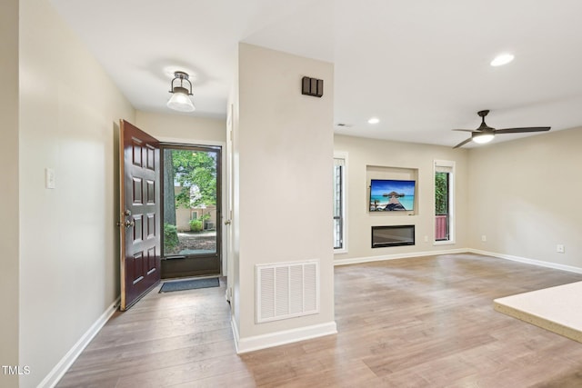 124 Twin Oaks Pl, Cary, NC 27511 - entryway with light wood-style flooring, recessed lighting, baseboards, ceiling fan, and a glass covered fireplace