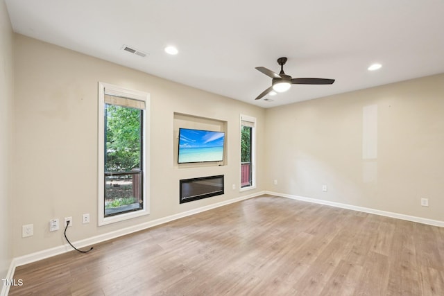 124 Twin Oaks Pl, Cary, NC 27511 - unfurnished living room featuring light wood-style floors, recessed lighting, baseboards, a ceiling fan, and a glass covered fireplace