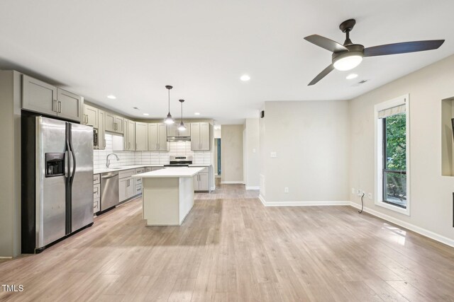 124 Twin Oaks Pl, Cary, NC 27511 - kitchen with stainless steel appliances, light countertops, decorative backsplash, light wood finished floors, and ceiling fan