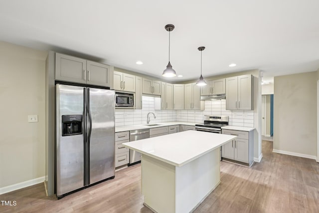 124 Twin Oaks Pl, Cary, NC 27511 - kitchen featuring appliances with stainless steel finishes, under cabinet range hood, a sink, tasteful backsplash, and gray cabinetry