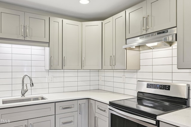124 Twin Oaks Pl, Cary, NC 27511 - kitchen with electric stove, a sink, under cabinet range hood, light countertops, and backsplash
