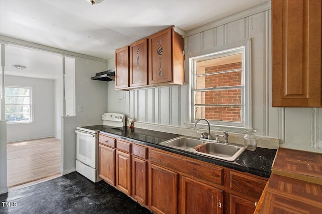 4412 Green Spring Dr, Garner, NC 27529 - kitchen featuring white range with electric stovetop, brown cabinetry, under cabinet range hood, and dark countertops