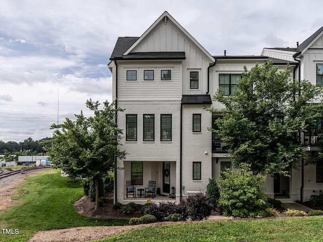 1610 Draper View Loop Unit 101, Raleigh, NC 27608 - view of front facade featuring board and batten siding, a front lawn, a porch, and a standing seam roof