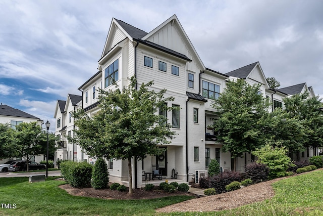 1610 Draper View Loop Unit 101, Raleigh, NC 27608 - view of side of home featuring board and batten siding, a lawn, and a patio area