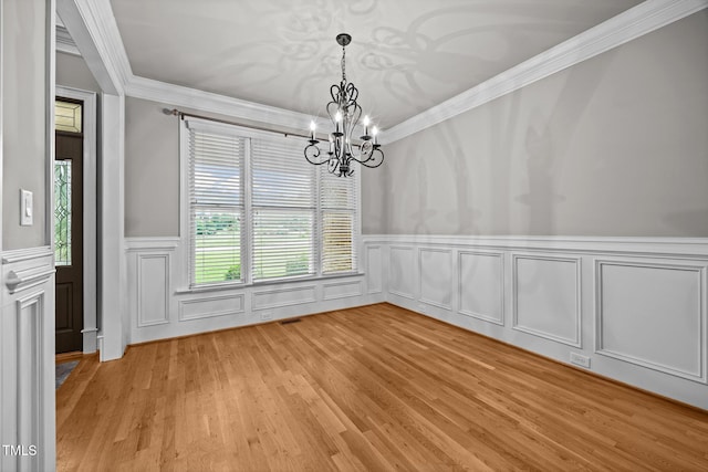 1124 Kalworth Rd, Wake Forest, NC 27587 - unfurnished dining area with a chandelier, a wainscoted wall, ornamental molding, a decorative wall, and light wood-type flooring