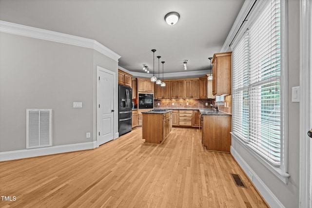 1124 Kalworth Rd, Wake Forest, NC 27587 - kitchen with black appliances, a center island, light wood-style flooring, crown molding, and tasteful backsplash