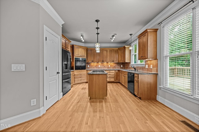 1124 Kalworth Rd, Wake Forest, NC 27587 - kitchen featuring black appliances, ornamental molding, light wood-style floors, a kitchen island, and tasteful backsplash