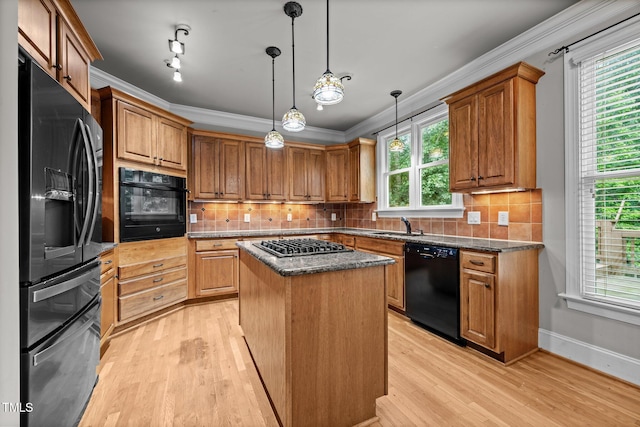 1124 Kalworth Rd, Wake Forest, NC 27587 - kitchen featuring black appliances, light wood-style flooring, a center island, crown molding, and decorative backsplash