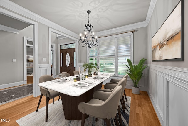 1124 Kalworth Rd, Wake Forest, NC 27587 - dining room featuring a decorative wall, a chandelier, a wainscoted wall, crown molding, and light wood-type flooring