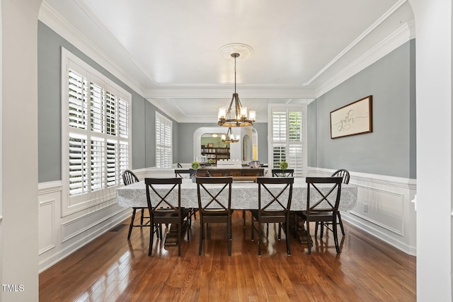 5516 Colonial Oaks Dr, Apex, NC 27539 - dining space featuring crown molding, wood finished floors, a decorative wall, a chandelier, and a wainscoted wall