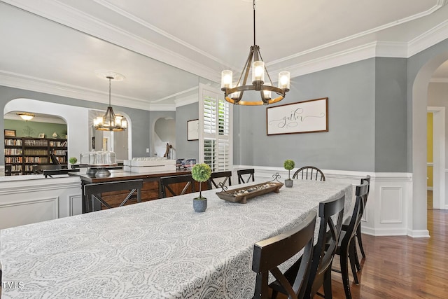 5516 Colonial Oaks Dr, Apex, NC 27539 - dining room with arched walkways, a chandelier, ornamental molding, wood finished floors, and wainscoting