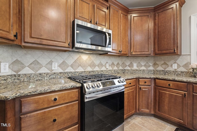 5516 Colonial Oaks Dr, Apex, NC 27539 - kitchen featuring appliances with stainless steel finishes, light stone counters, tasteful backsplash, and brown cabinets