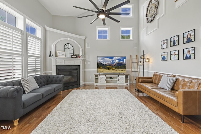 5516 Colonial Oaks Dr, Apex, NC 27539 - living area with ceiling fan, a fireplace with flush hearth, dark wood-style floors, a towering ceiling, and baseboards