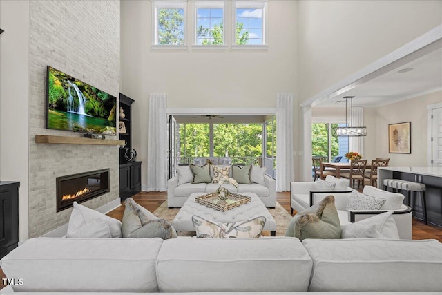 111 Stone Park Dr, Wake Forest, NC 27587 - living room with a towering ceiling, a large fireplace, plenty of natural light, a chandelier, and wood finished floors