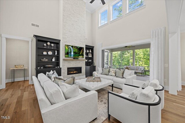 111 Stone Park Dr, Wake Forest, NC 27587 - living room featuring ceiling fan, a high ceiling, a fireplace, wood finished floors, and baseboards