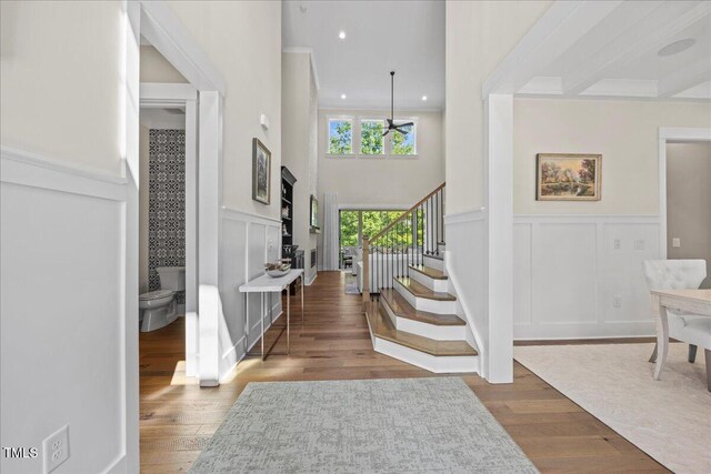 111 Stone Park Dr, Wake Forest, NC 27587 - entryway featuring a decorative wall, stairs, wood finished floors, wainscoting, and a towering ceiling