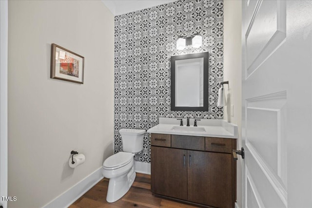111 Stone Park Dr, Wake Forest, NC 27587 - half bathroom with wallpapered walls, toilet, vanity, baseboards, and wood finished floors