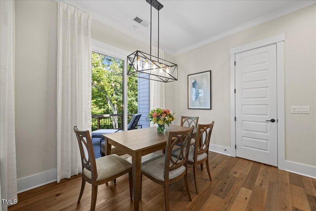111 Stone Park Dr, Wake Forest, NC 27587 - dining area featuring baseboards, a chandelier, dark wood-type flooring, healthy amount of natural light, and crown molding