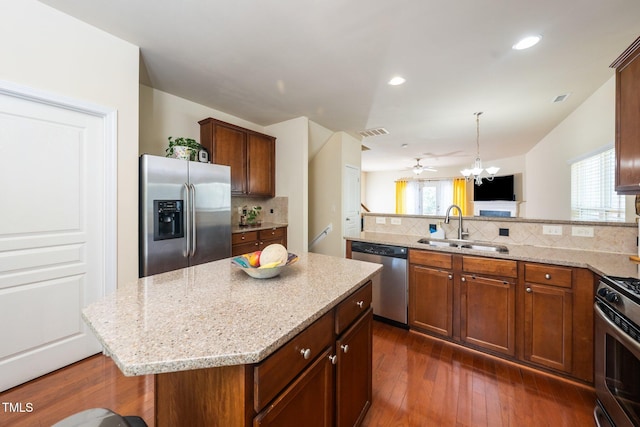 1017 Frank Page Dr, Cary, NC 27511 - kitchen featuring appliances with stainless steel finishes, a sink, a peninsula, decorative backsplash, and light stone counters